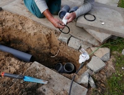 Person working on underground pipes