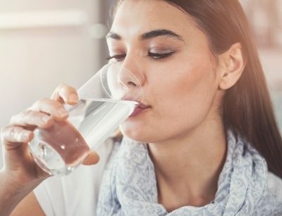 woman drinking filtered water from a glass